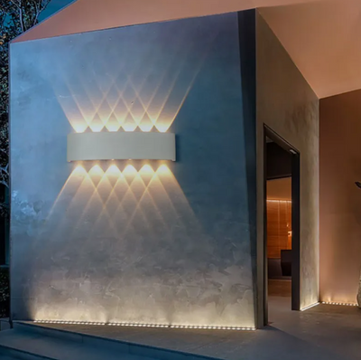 Modern wall-mounted light fixture on a textured wall with a softly lit interior.