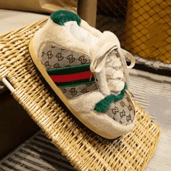 Children's shoe with Gucci logo on a woven surface
